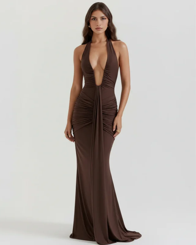 Front full-length portrait of the Alessandra brown maxi gown in deep chocolate jersey, featuring an ultra-low plunging halter neck, structural hip ruching, and a dramatic vertical front drape.