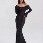 Front full-length shot of the Amandine off-the-shoulder maxi gown in sheer black lace, featuring an elegant tie-front detail at the neckline, dramatic bell sleeves, and a floor-sweeping mermaid train.