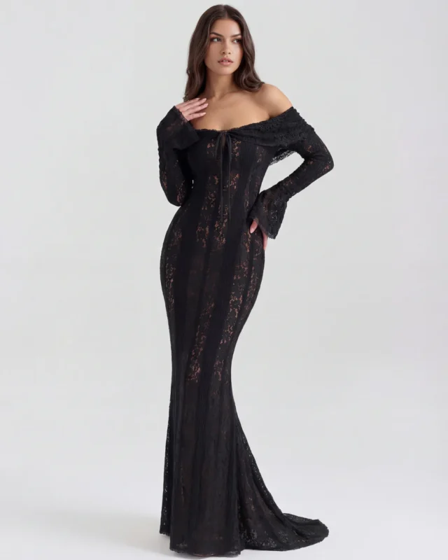 Front full-length shot of the Amandine off-the-shoulder maxi gown in sheer black lace, featuring an elegant tie-front detail at the neckline, dramatic bell sleeves, and a floor-sweeping mermaid train.