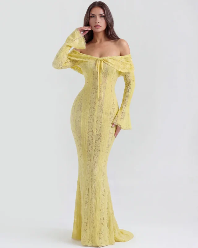 Front full-length portrait of the Amandine off-the-shoulder maxi gown in soft pastel yellow lace, showcasing the keyhole front ribbon tie, long bell sleeves, and floor-sweeping column skirt.