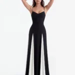 Front full-length studio portrait of the Amara black and white maxi dress, showing a subtly curved sweetheart neckline with thin spaghetti straps, a fitted black bodice, and an A-line skirt with dramatic contrasting white godet panels.