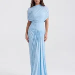 Front full-length view of The Camille Asymmetrical Draped Shawl Maxi Gown in baby blue, showcasing the elegant crew neckline, integrated upper-body wrap shawl, and dramatic column-pleated skirt.