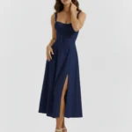 Front full-length portrait of the Capri dark blue midi dress, showcasing a structured corset bodice with a gathered milkmaid bust, tied neckline details, and a flowing skirt featuring a high thigh slit
