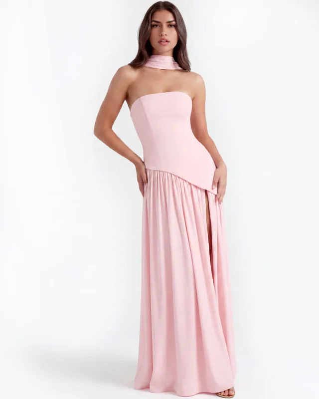 Balanced front portrait of the blush pink strapless corset maxi gown, displaying the sharp diagonal waist seam line and a flowing floor-length hemline.