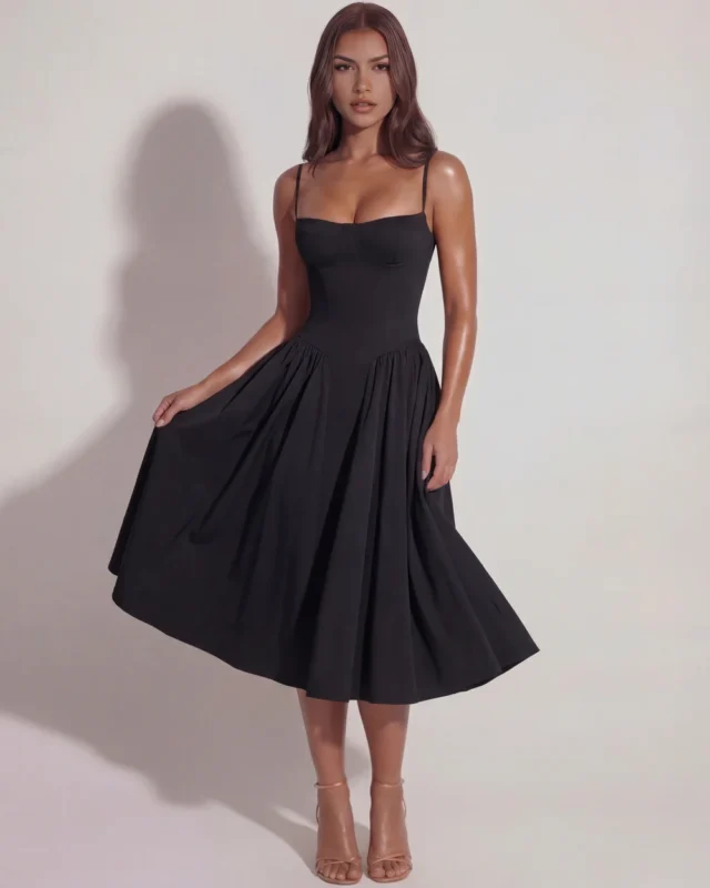Front full-length view of The Delphine Bustier Midi Dress in timeless black, showcasing the romantic structured underwired corset bodice, minimal spaghetti straps, and gathered pleat flare skirt.
