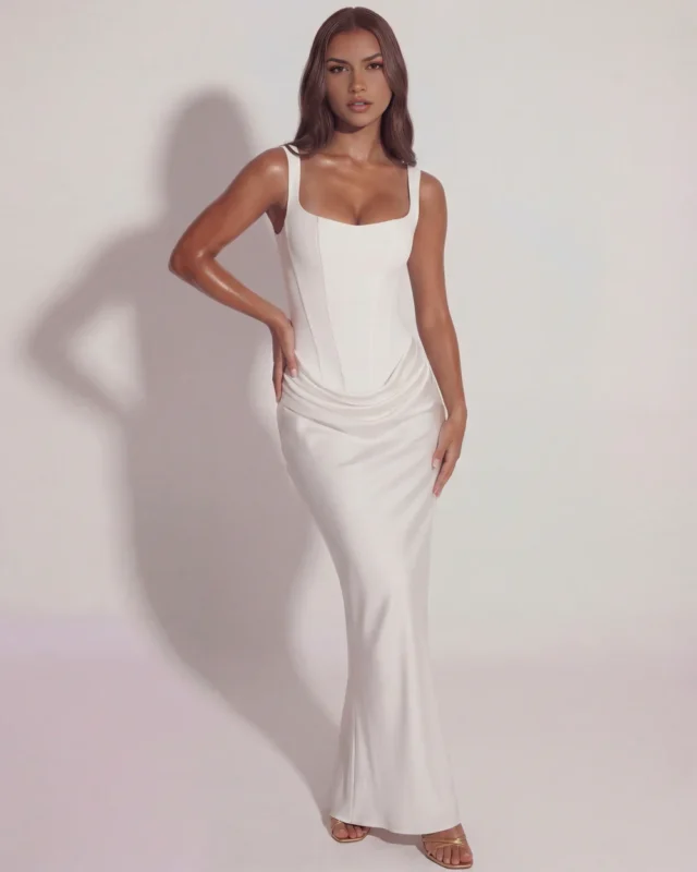 Front full-length view of the Eleonor structured corset maxi gown in elegant ivory white, showcasing a crisp square neckline, body-contouring panel seams, and an overlapping cowl drape at the drop waist.