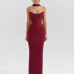 Front full-length portrait of the Victoria burgundy maxi gown, showcasing a strapless curved sweetheart neckline with fine ruching across the corseted mesh bodice, a matching wine-colored fabric neck choker, and a sleek column-style skirt.