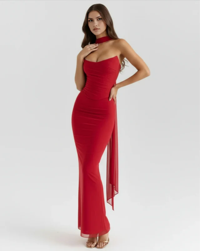Front full-length portrait of the Victoria red maxi gown, showcasing a strapless curved sweetheart neckline with fine ruching across the corseted mesh bodice, a matching red fabric neck choker, and a sleek column-style skirt paired with gold heels.