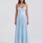 Front full-length portrait of the Nerida strapless maxi gown in baby blue, showcasing the unique gathered pleating on the sweetheart bustier cups, a smooth contoured waist, and a floor-sweeping accordion pleated skirt.