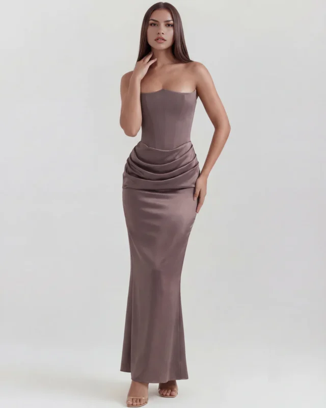 Front full-length shot of the Rosalinda strapless corset maxi gown in a sophisticated smoke taupe grey, featuring an architectural pointed neckline and elegant cowl draping across the hips.