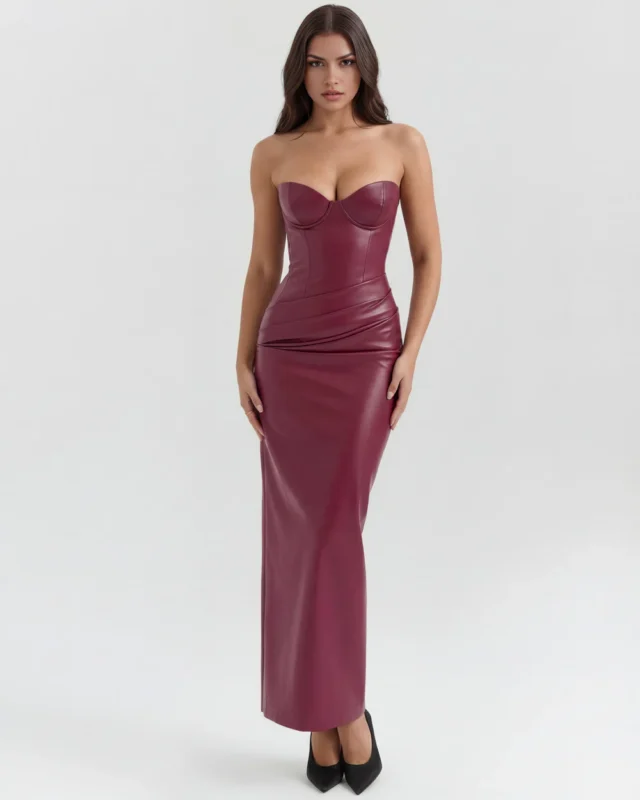 Front full-length studio view of the Victoria burgundy dress in wine-red faux leather, featuring a strapless sweetheart bodice with structured molded cups and a multi-directional draped hip design.